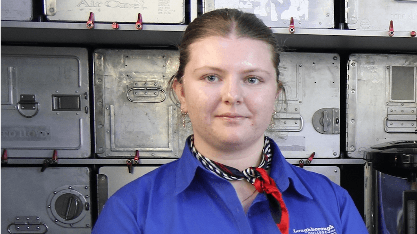 Emma standing in travel and tourism uniform in front of cargo holders